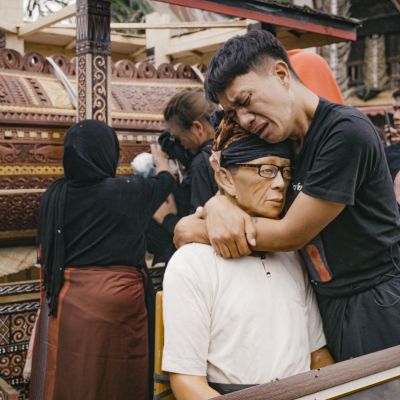 Alan hold his dad_s _Tau_ in Rambu Solo_ ceremony